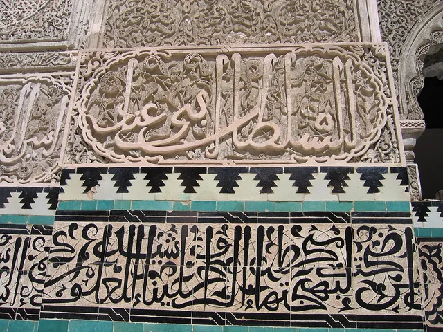 جصٌّ منقوش يذكر السلطان أبا عنان، تحته شريط من حروف الزليج، المدرسة البوعنانية