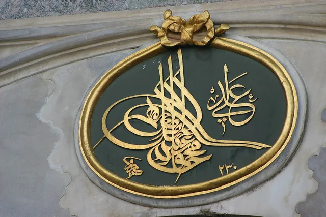 طغراء لمحمود الثاني على الشكل الذي أصلحه مصطفى راقم، بالذهب على الأخضر، فوق باب السلام